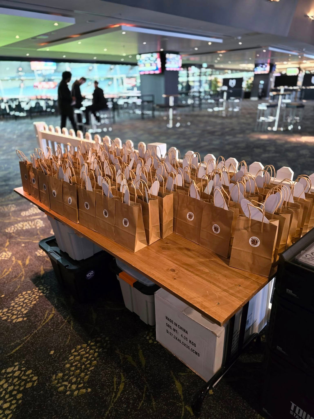 Gift bags sitting on a table in a big open venue.