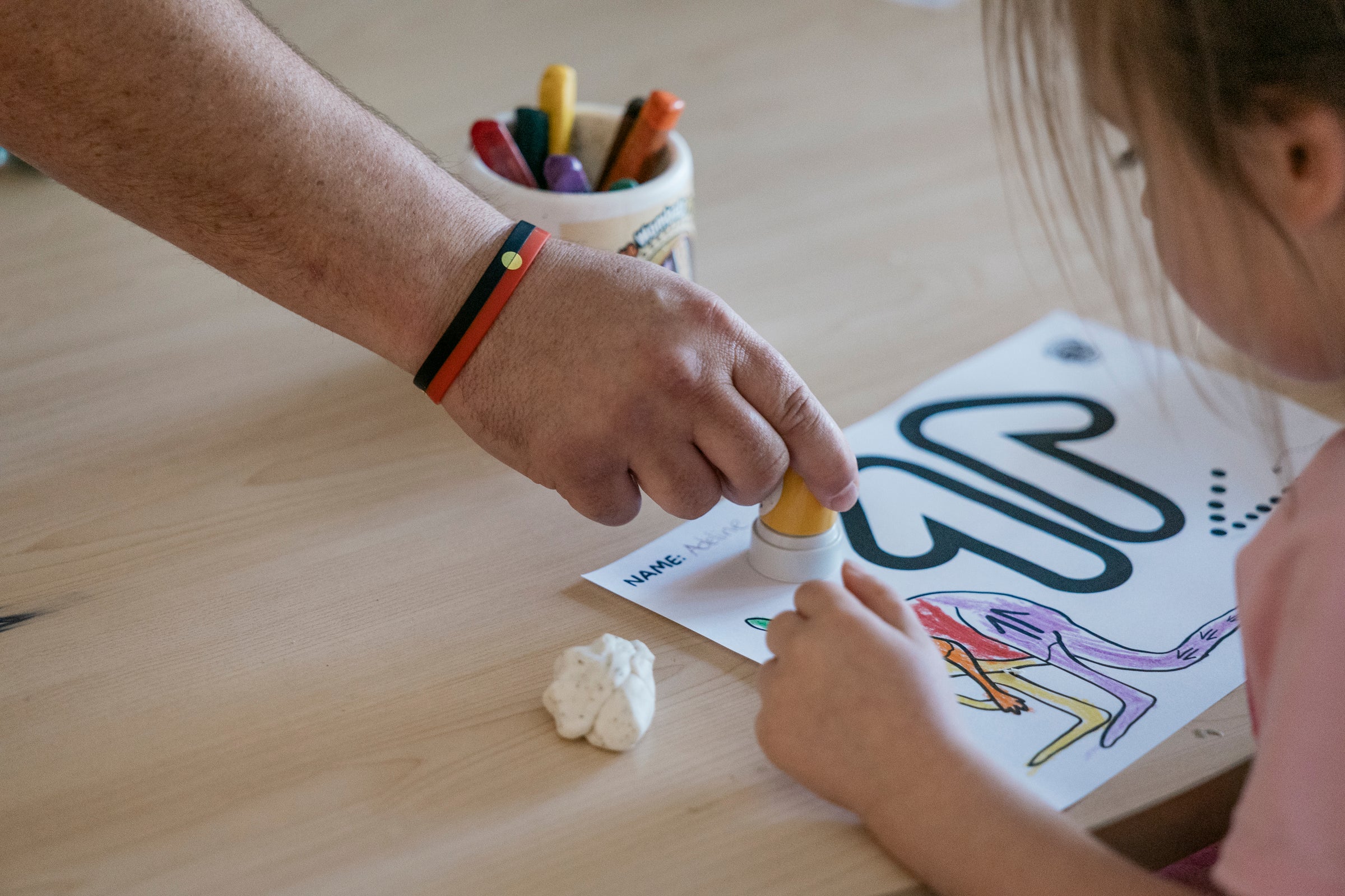 Man stamping child's artwork